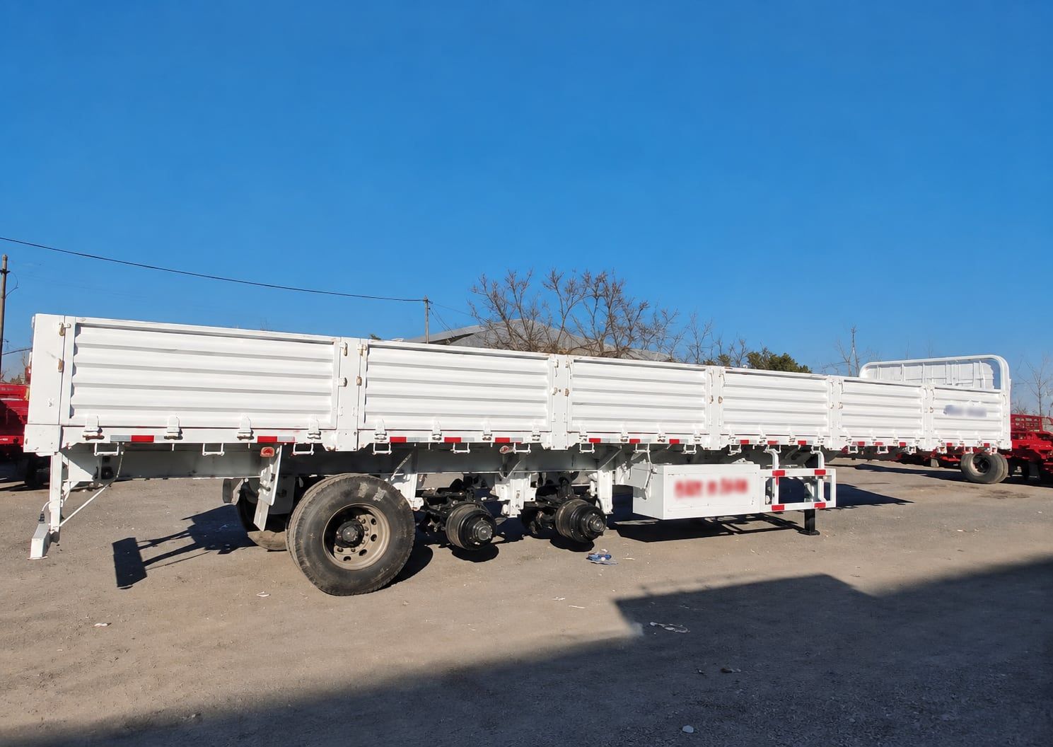 Semi-remorque CYP9400L à ridelles de 800 mm, vue de côté, ridelles relevées, longueur totale et trois essieux visibles