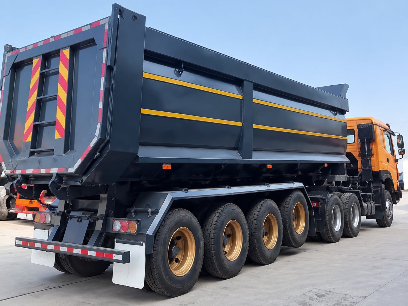 Semi-remorque benne en U CYP9402ZZX de 40 t, vue arrière, porte arrière et barre anti-encastrement arrière, attelée à un tracteur routier