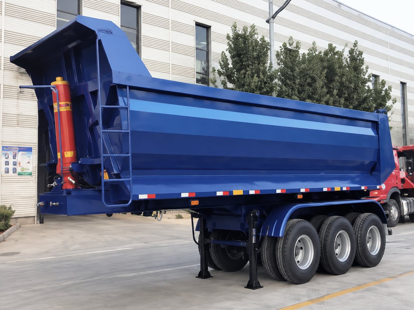 Semi-remorque benne en U CYP9402ZZX de 40 t, en cours de basculement, benne relevée, vue de trois quarts arrière