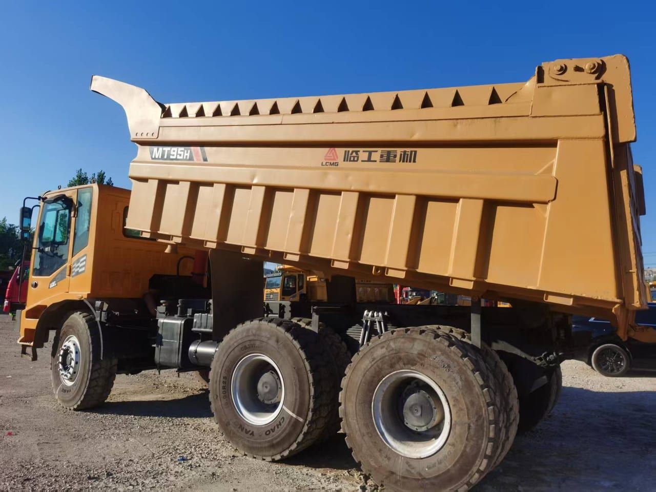 LGMG MT95H side elevation: the full length of the dump body with its rock guard, three axles and the cab at the front