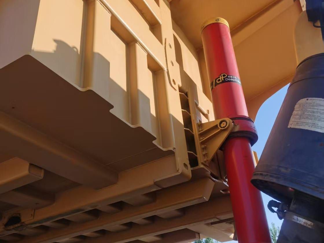 LGMG MT95H under the raised dump body, showing the red hoist cylinder and the body floor