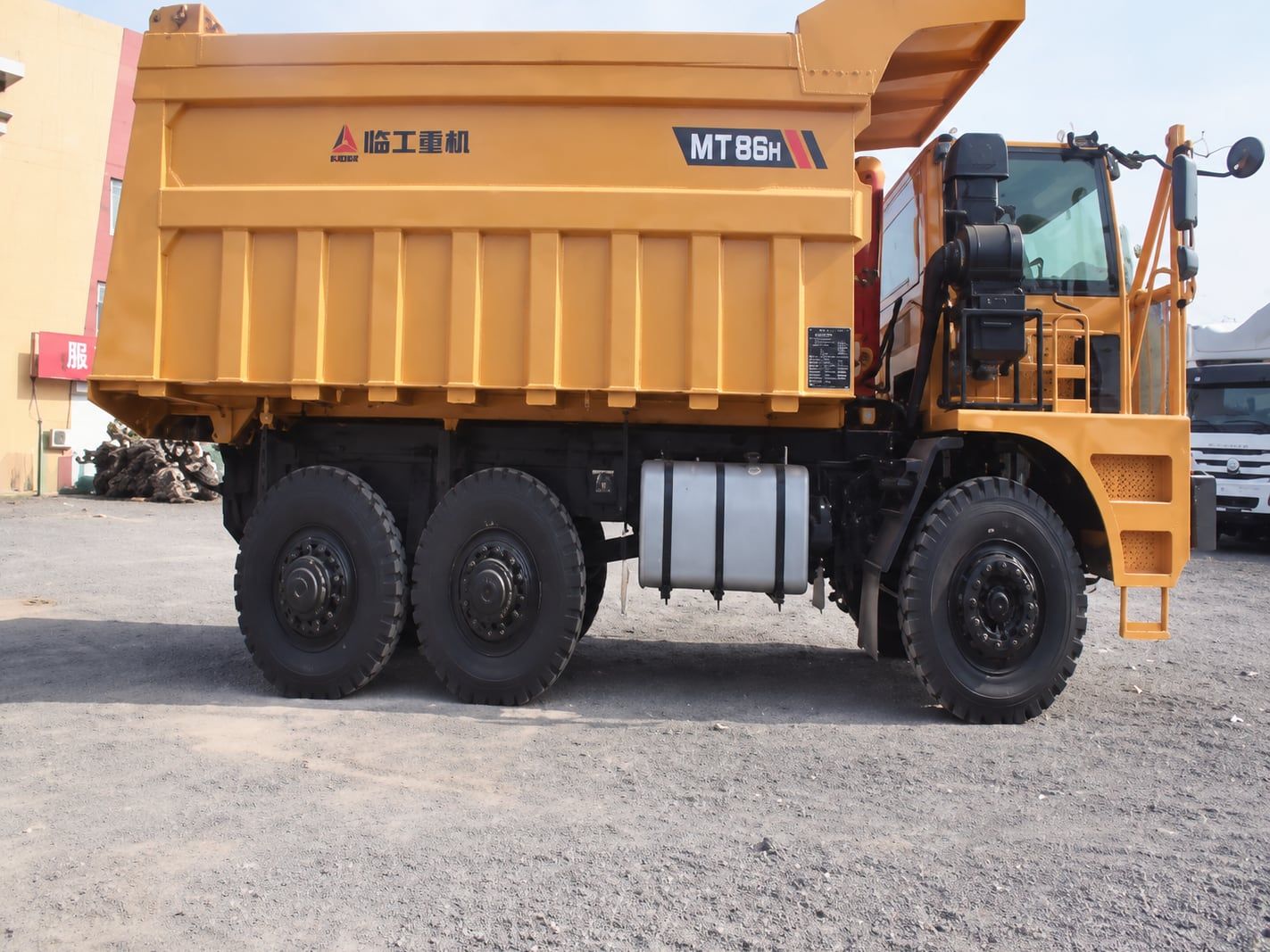 Camion minier à caisse large SDLG, vue de côté, toute la longueur de la benne et les essieux arrière visibles