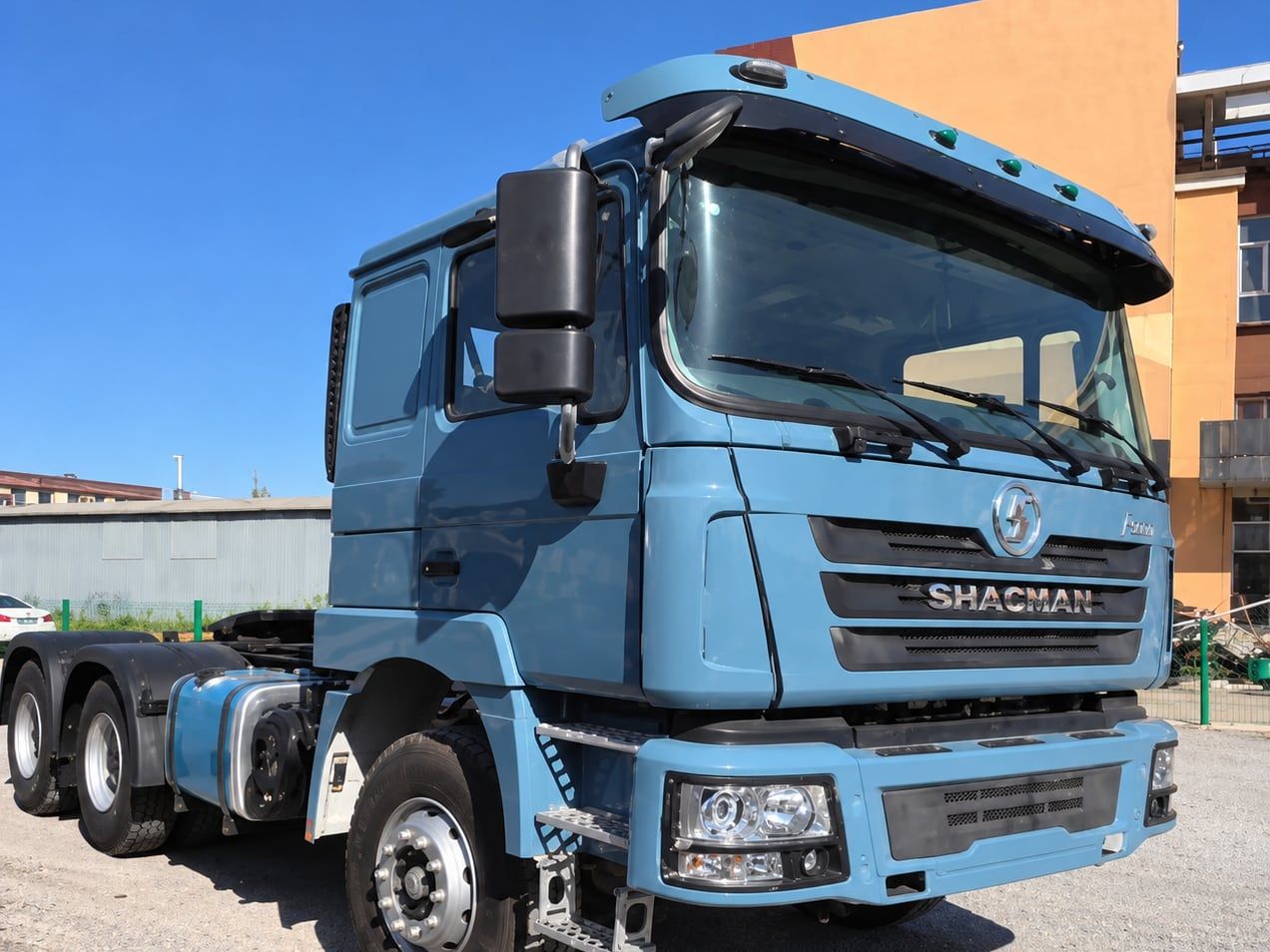 Tracteur routier Shacman Delong F3000 6×4, vue de trois quarts avant dans le parc, cabine bleu clair