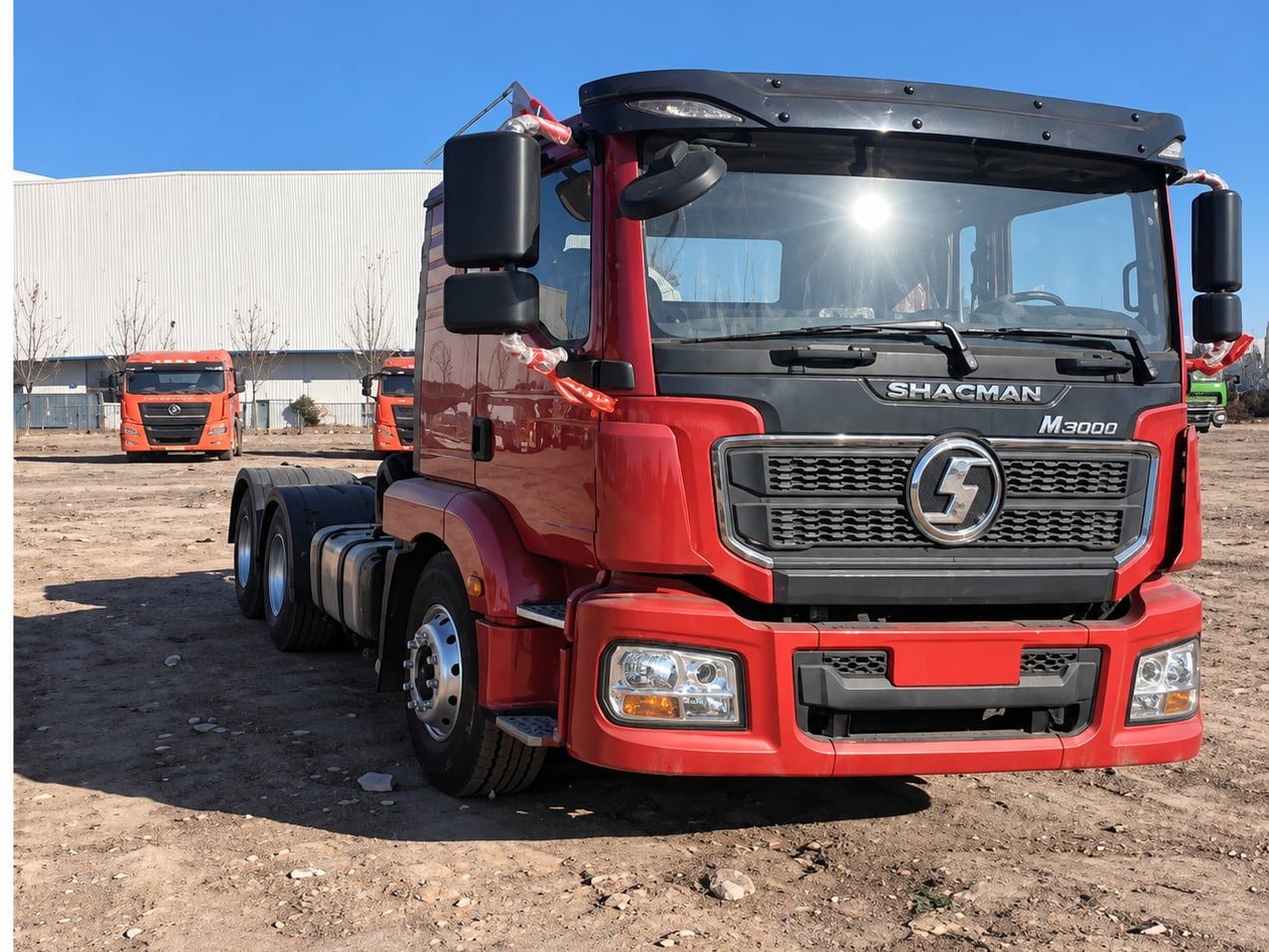Tracteur routier Shacman Delong M3000 6×4, vue de trois quarts avant dans le parc, cabine rouge et sellette libre