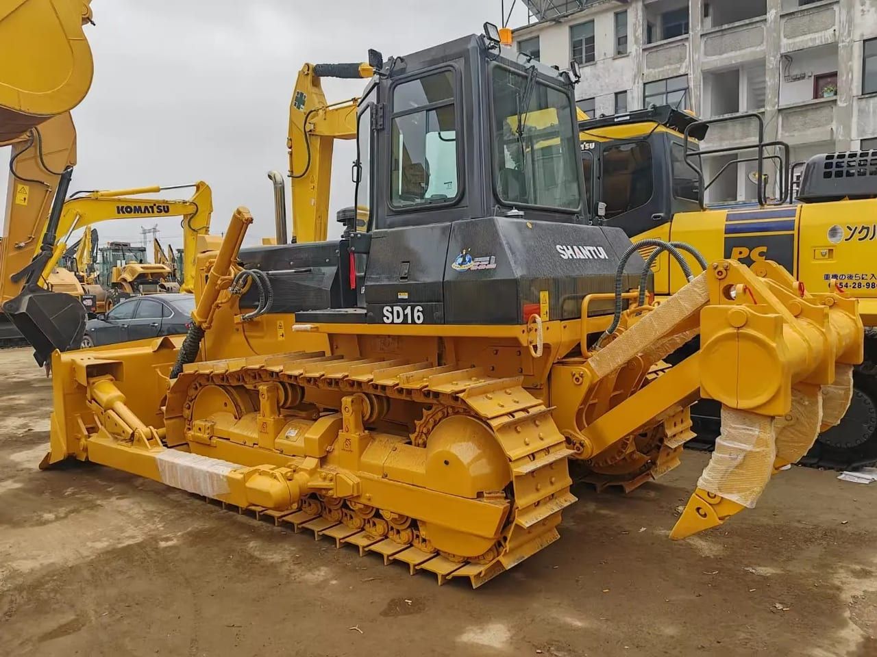 Shantui SD16 bulldozer side elevation, blade at the front, rear ripper and the SD16 badge on the cab