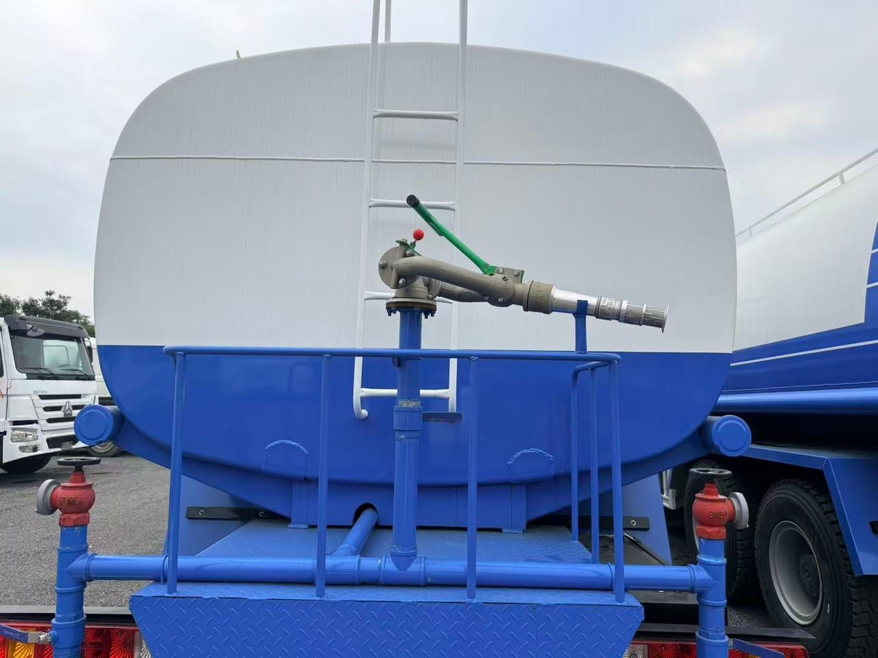 Arrière de la citerne d'eau : échelle d'accès, canon à eau monté en partie haute et tuyauterie d'arrosage arrière