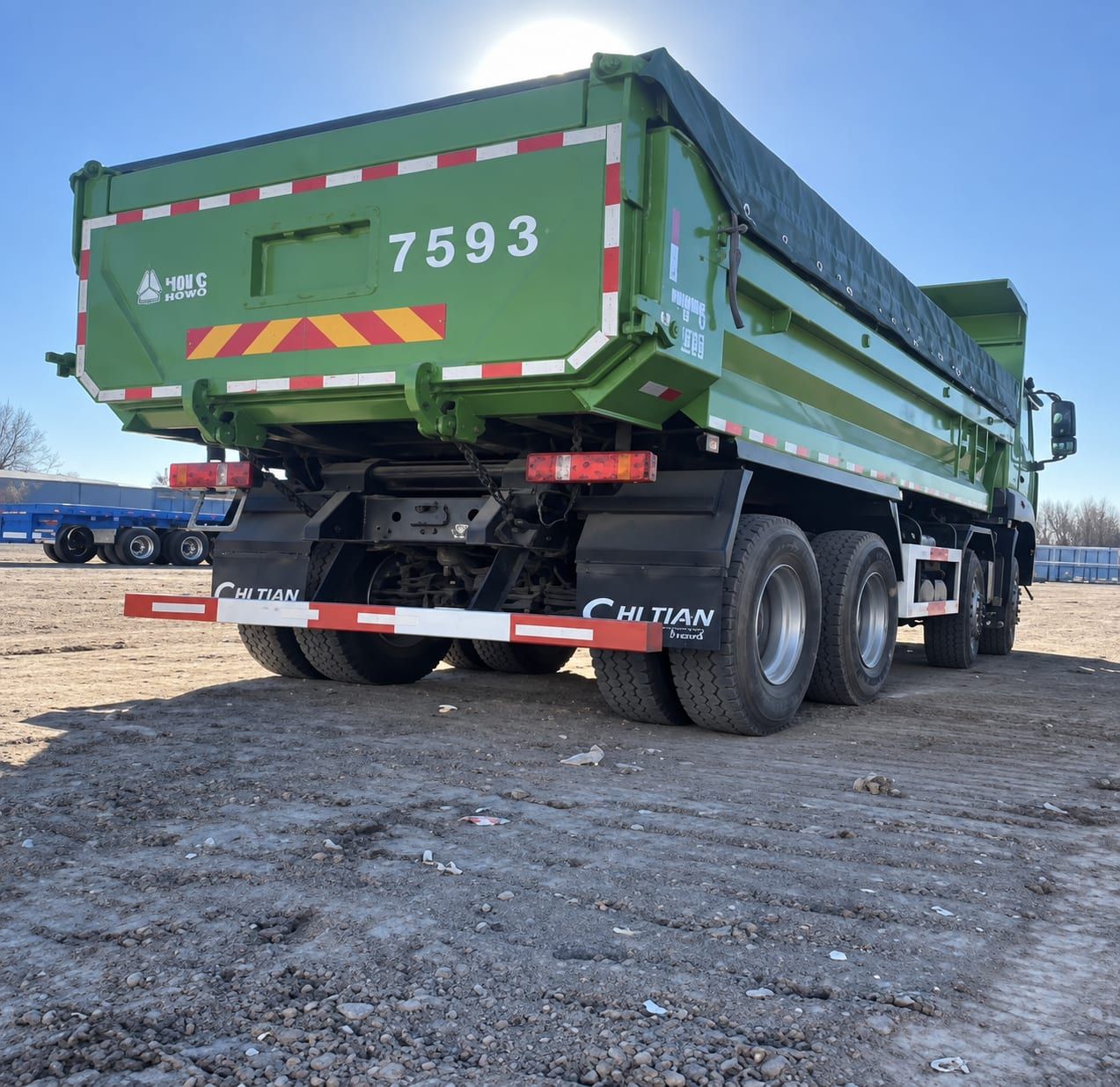 Camion benne Sinotruk HOWO 8×4, vue arrière, porte arrière, bâche et essieux arrière visibles