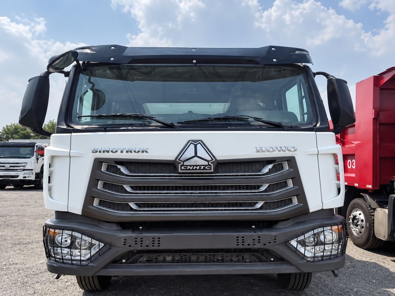 Camion benne Sinotruk HOWO NX 6×4, vue de trois quarts avant, cabine blanche et benne derrière