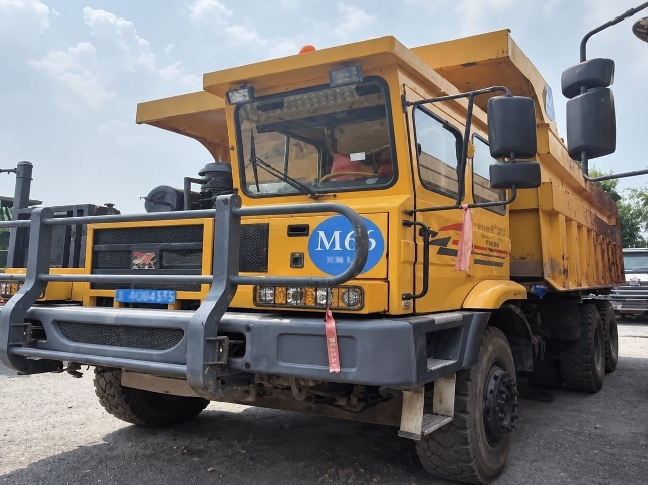 Camion minier à caisse large Tonly, vue de trois quarts avant, cabine jaune et pare-buffle, benne vide